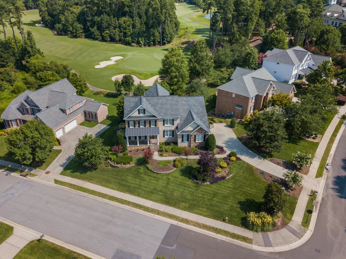 Aerial view of homes beside a golf course and tree-lined streets